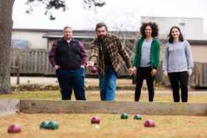 Four people playing bocce ball.
